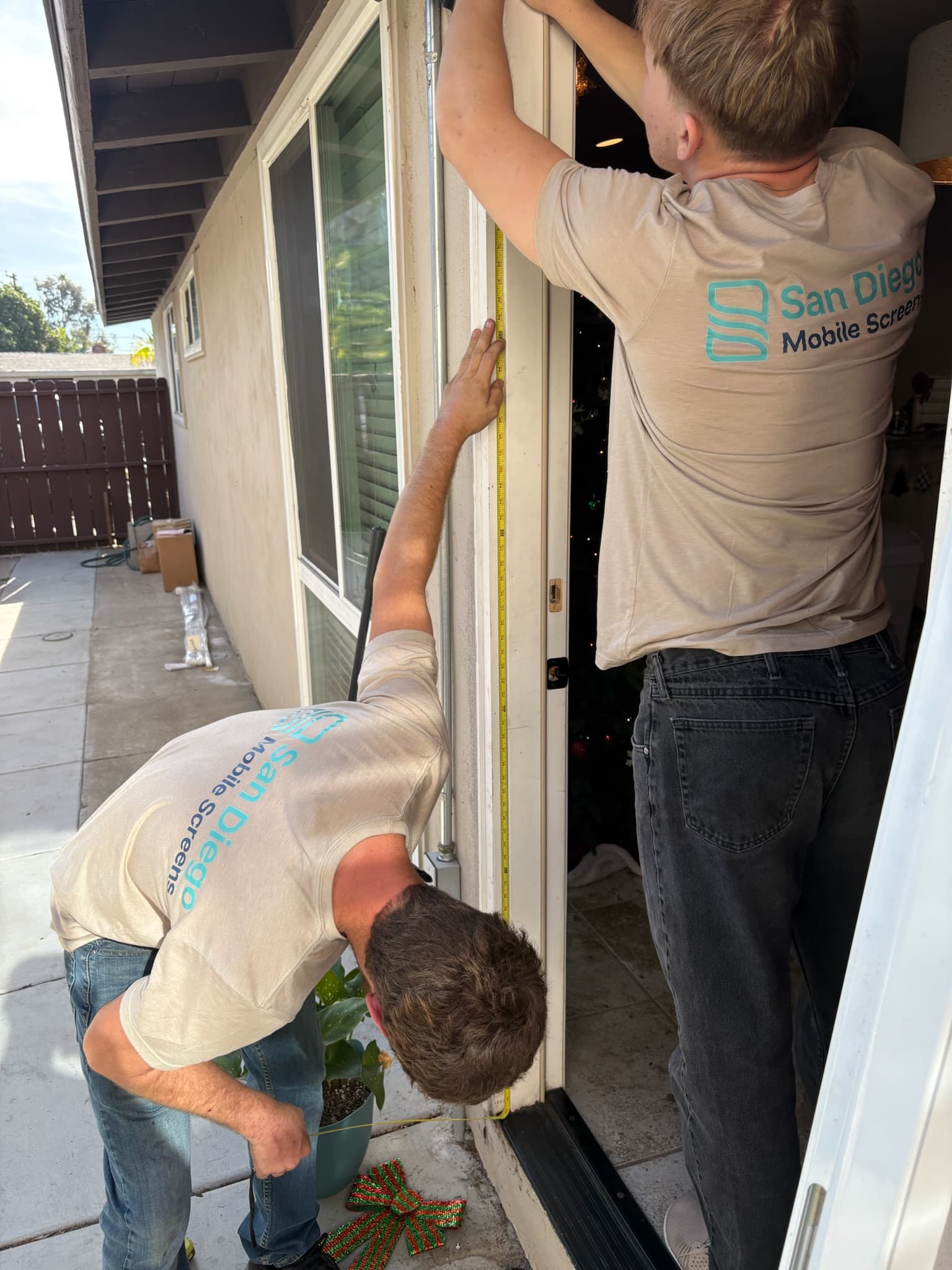 Roll-A-Way retractable screen door installed on a San Diego home entry, fully deployed with mesh across the doorway
