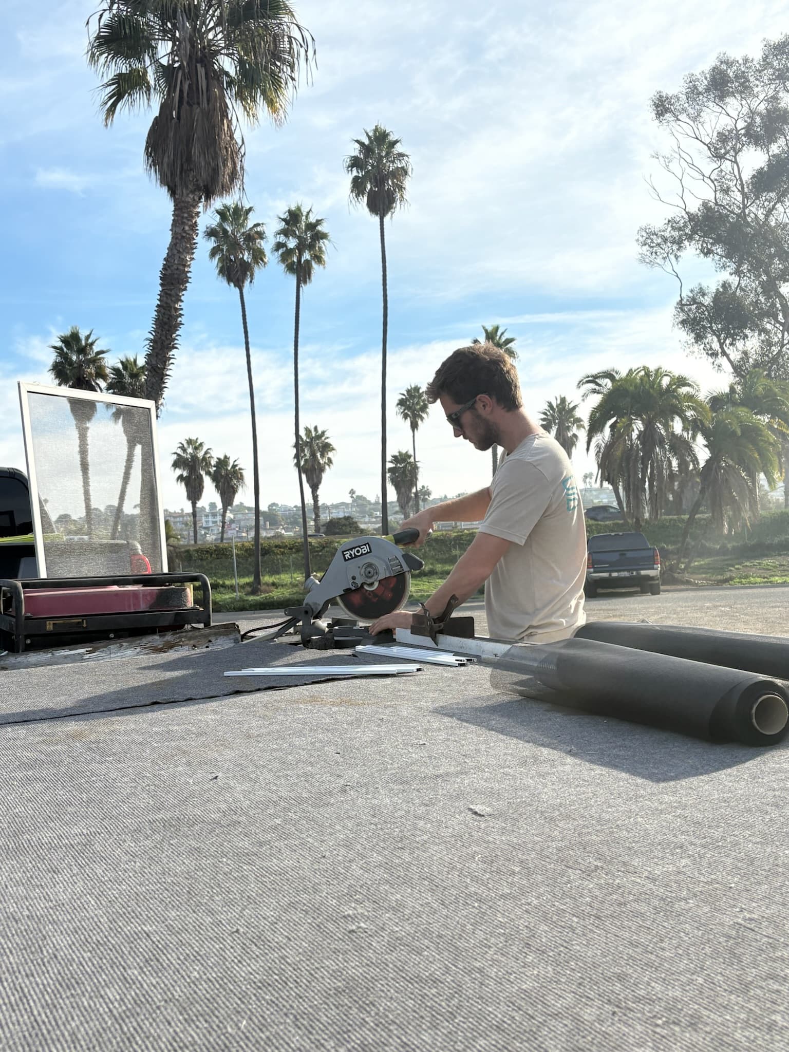 Technician cutting screen frame with a miter saw outdoors in San Diego
